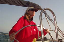 Alex at the helm of her sailboat, Sea Natural, off the Santa Barbara coast